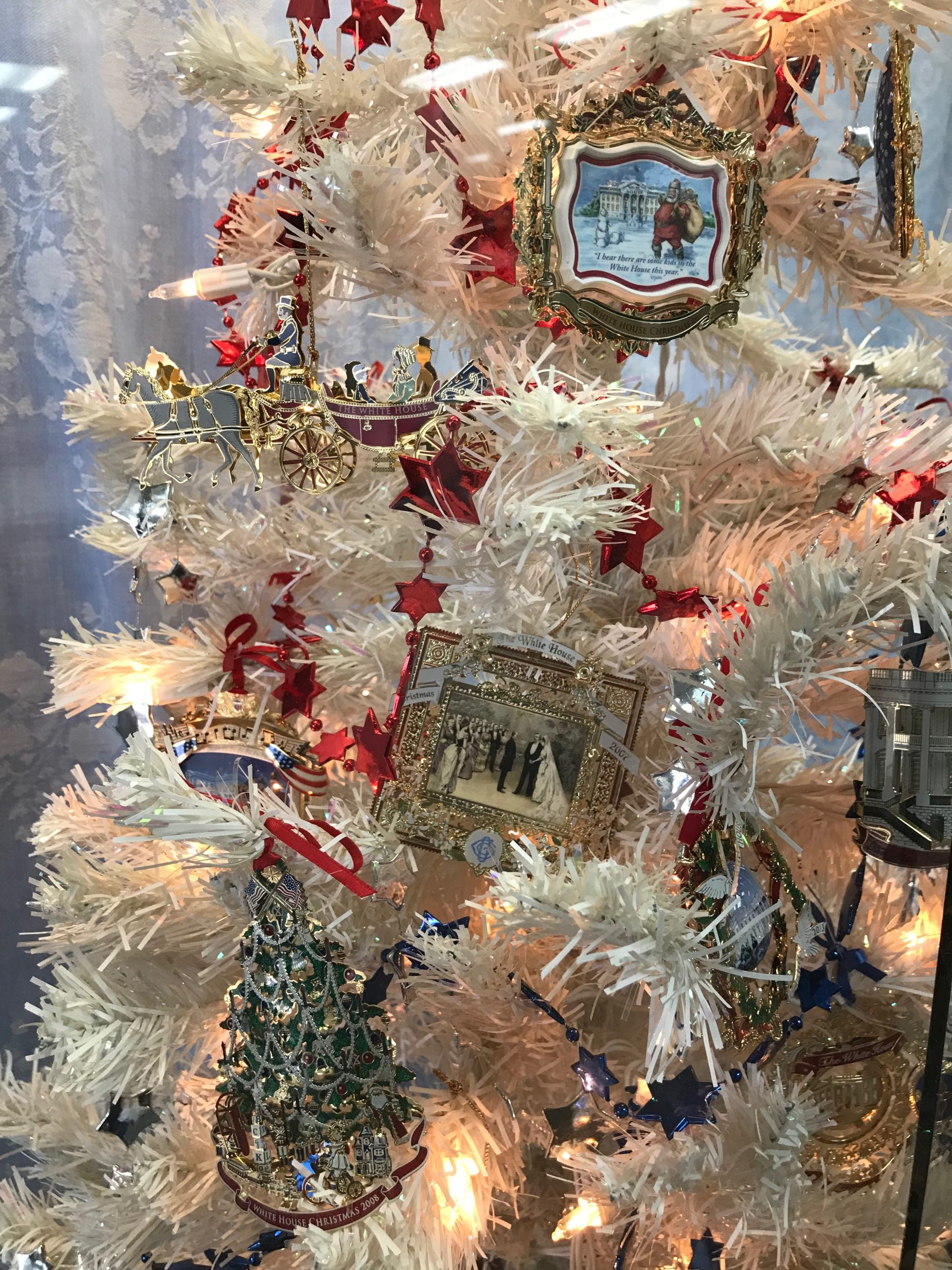 Close-up view of Christmas ornaments, including painted scenes, a wagon and a Christmas tree.