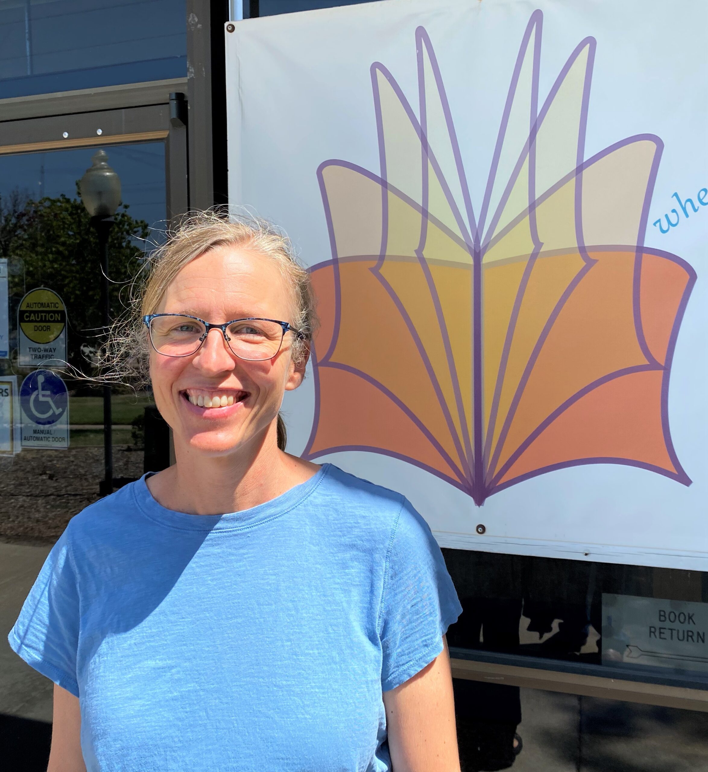 Sara Rickard poses for a photo outside the library's front doors.