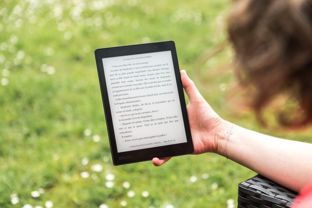 A woman reads an e-ink tablet.